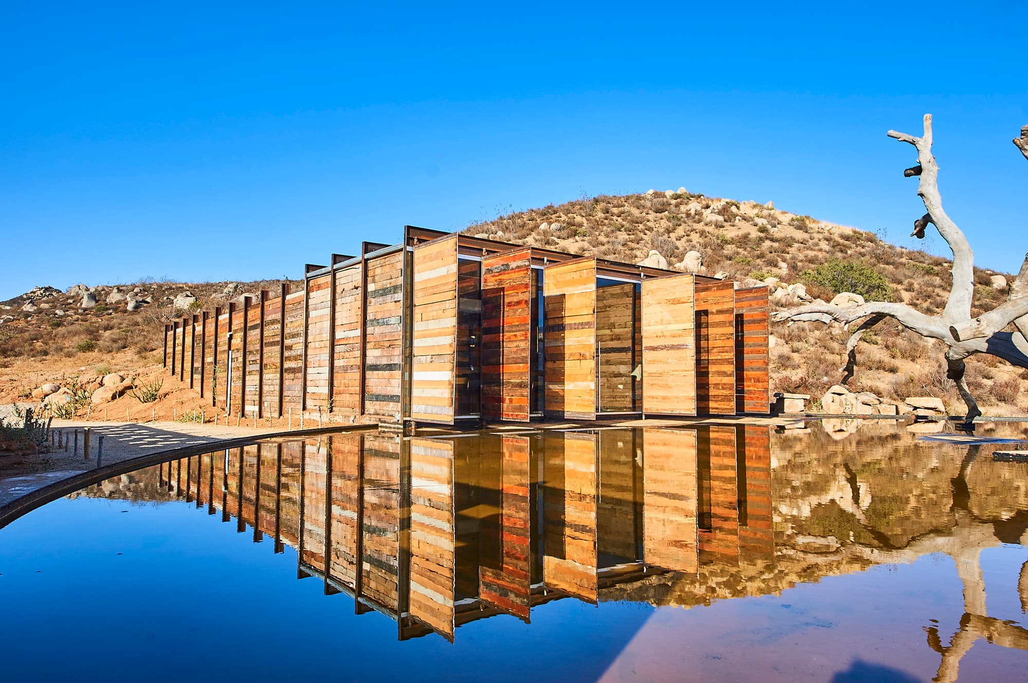 Bruma Wine Resort — Architektur aus Recycling-Holz mit Wasserreflexion