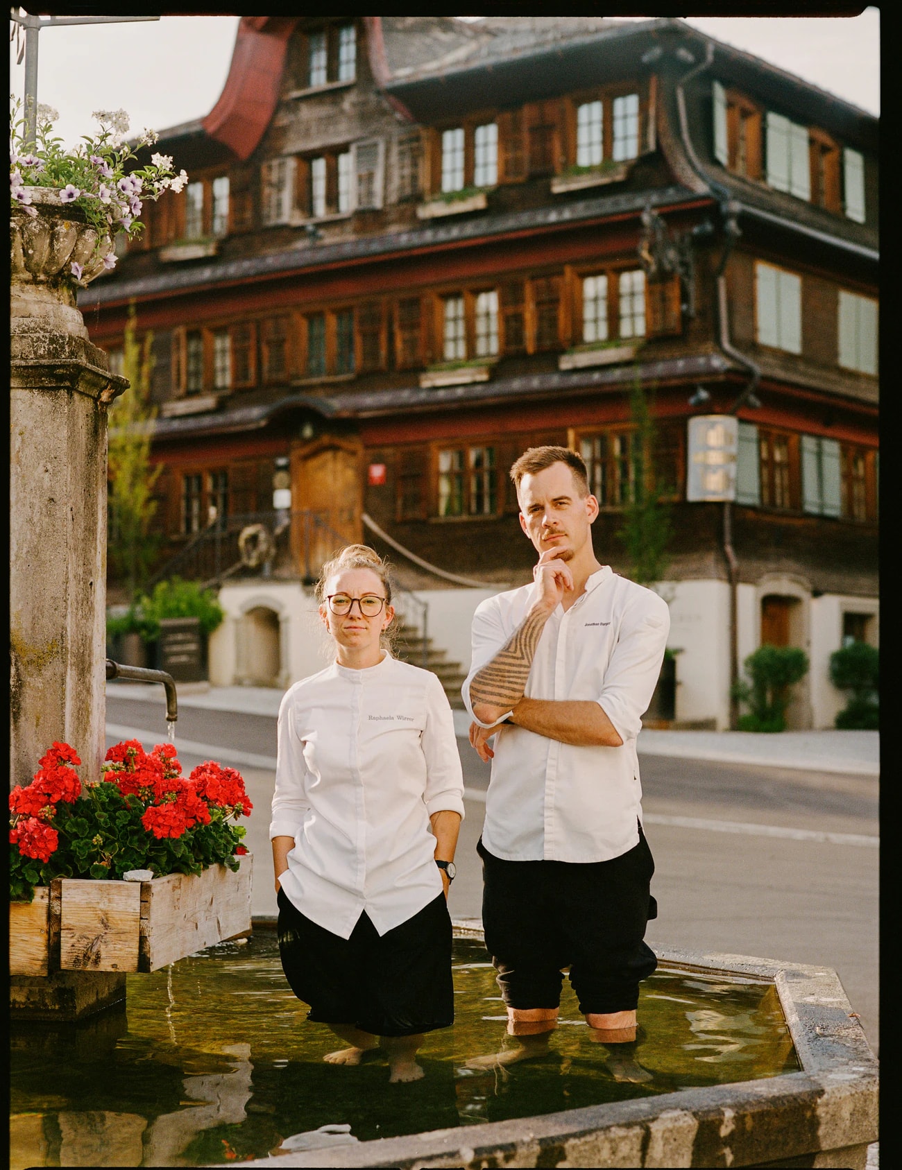 Raphaela und Jonathan Burger in Kochjacken im Dorfbrunnen vor dem Hirschen.
