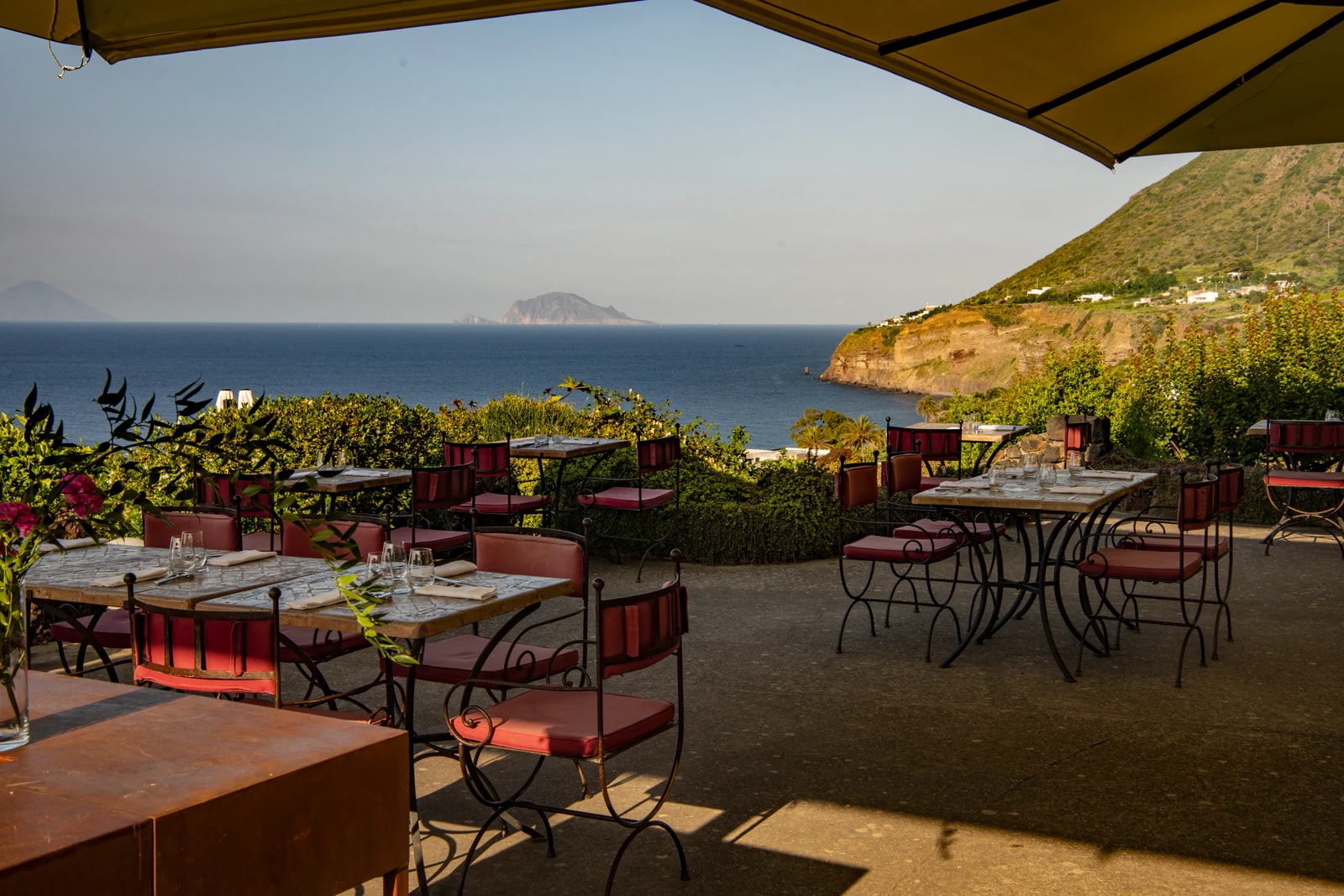 Bistrot-Terrasse unter Sonnenschirmen mit Blick aufs Meer und auf Panarea.
