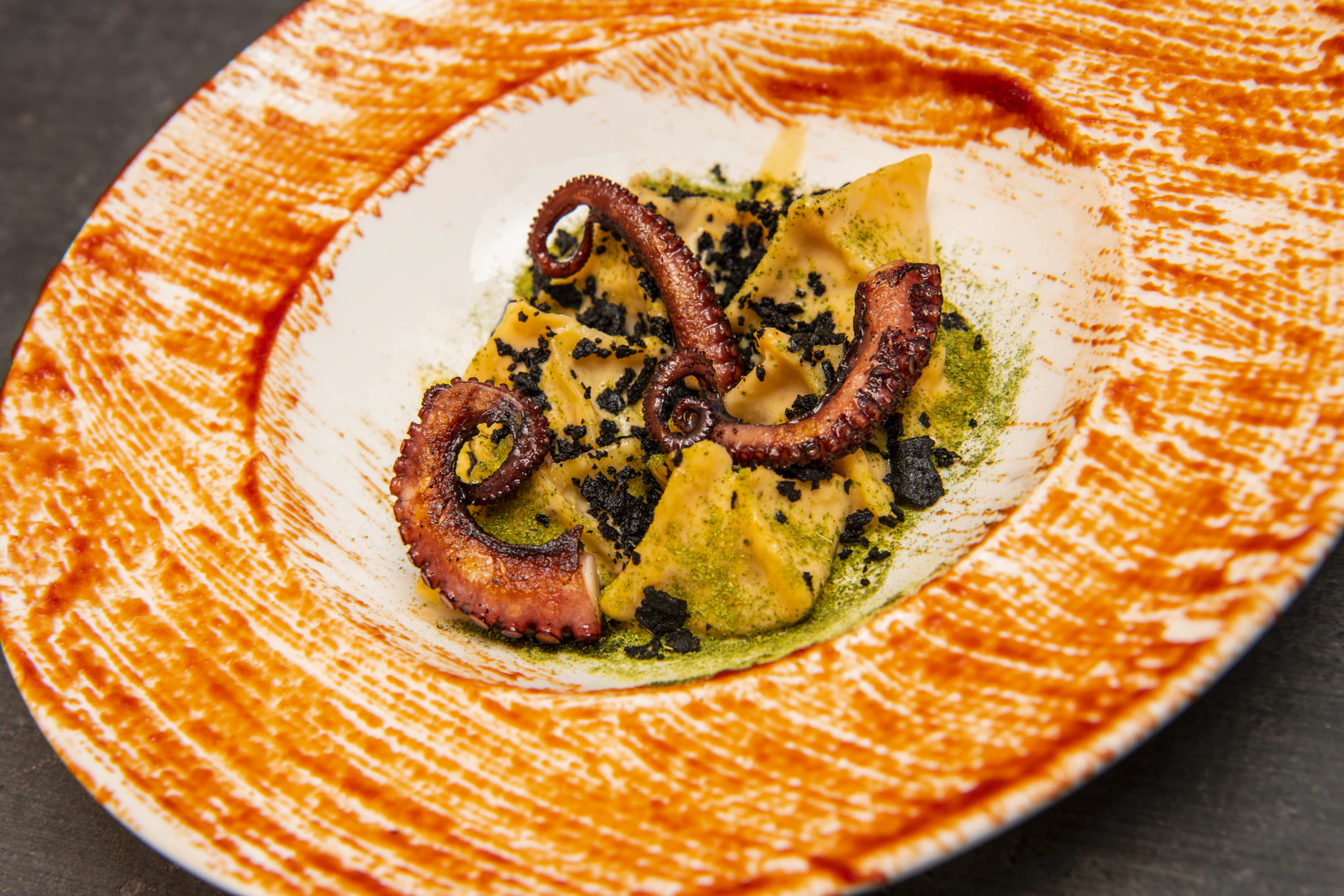 Teigtaschen mit Oktopus, Nduja, Kartoffeln, Zitrone und schwarzen Oliven.