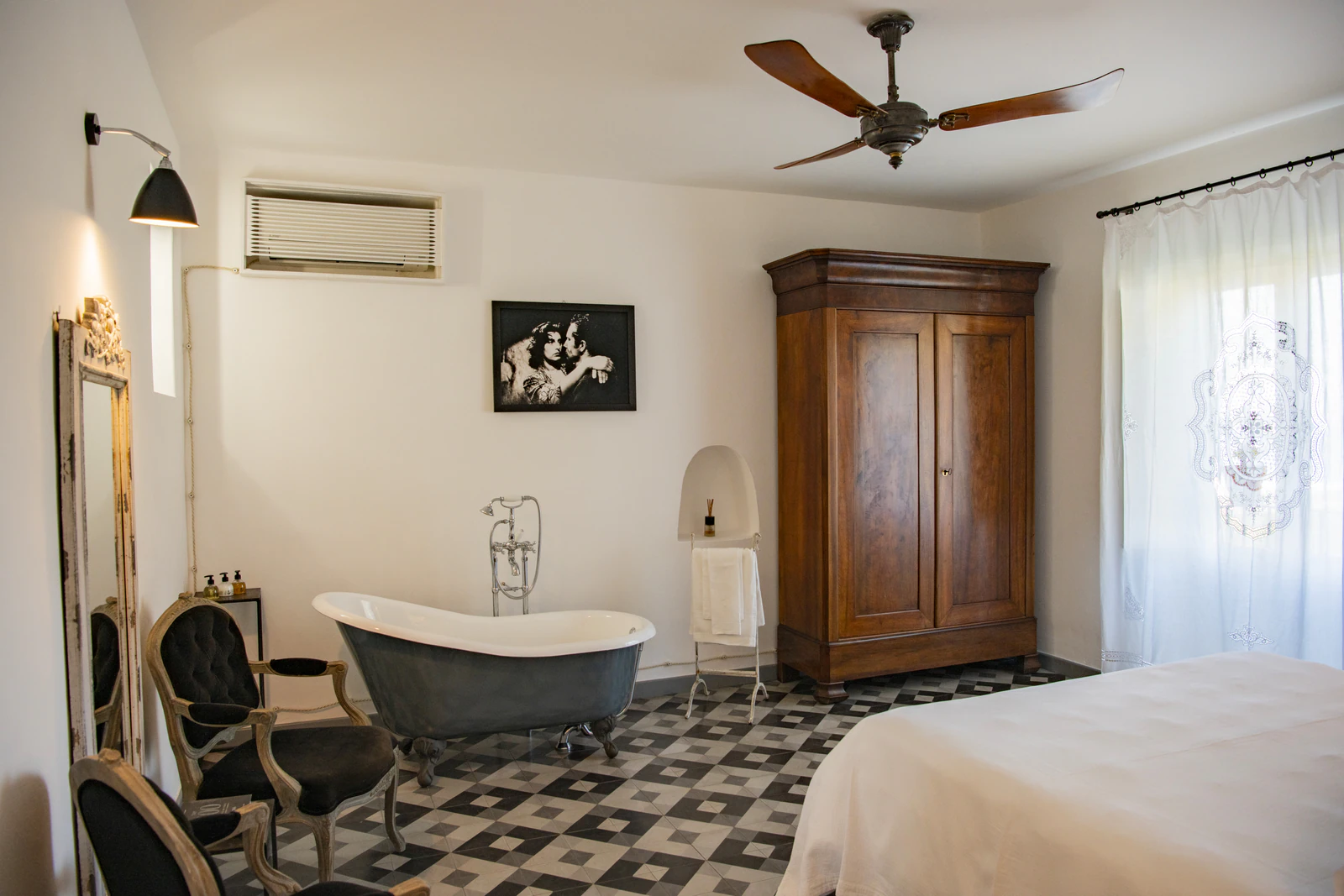Suite mit frei stehender Wanne, Holzschrank und Deckenventilator.