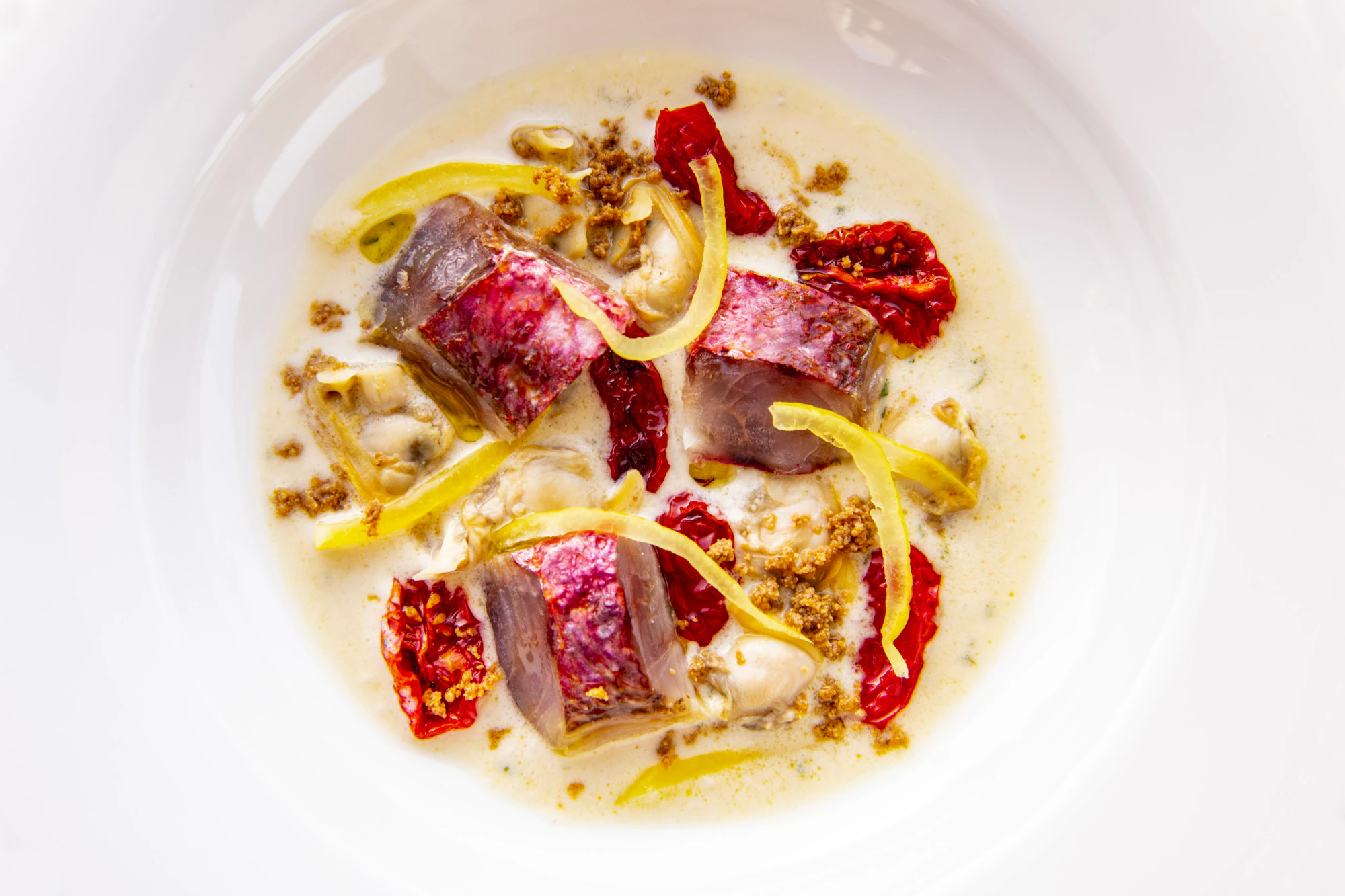 Rotbarbe auf Mandelsuppe mit Venusmuscheln, Zitrone und Bottarga.