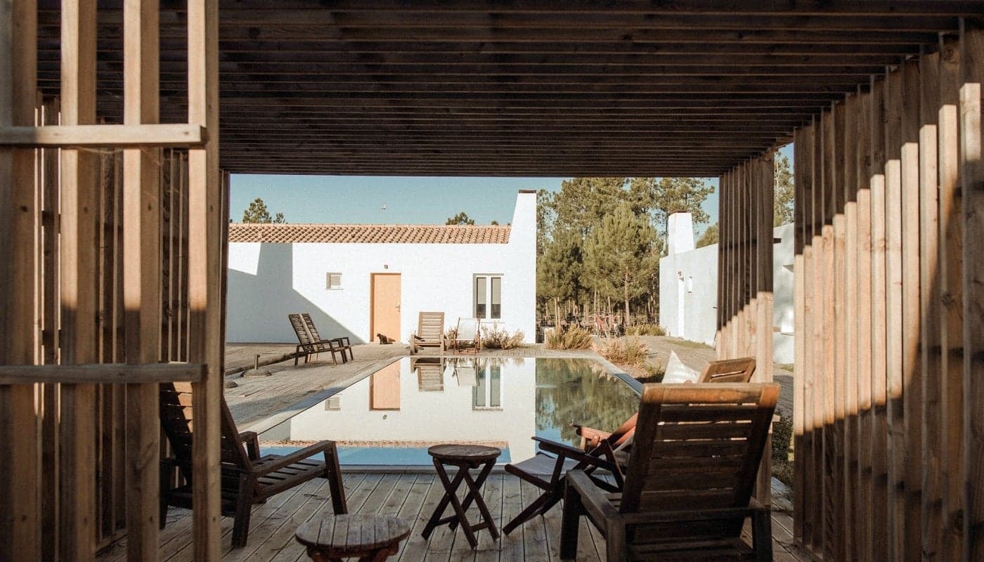 Craveiral Farmhouse — outdoor chairs and pool at dusk, Alentejo