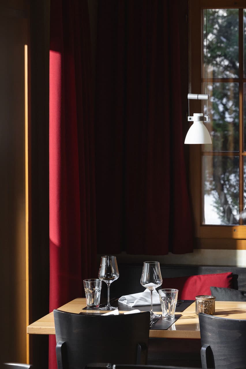 Stuba Adelboden — Intimate interior with red curtains and winter mountain view