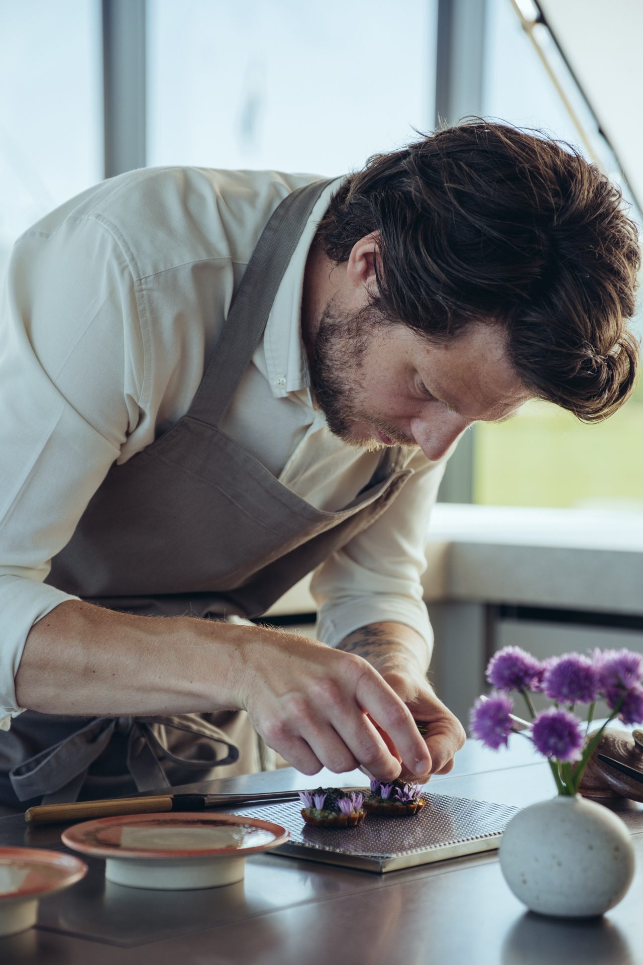 Restaurang ÄNG, Ästad Vingård — Küchenchef Filip Gemzell richtet einen Gang mit essbaren Blüten an