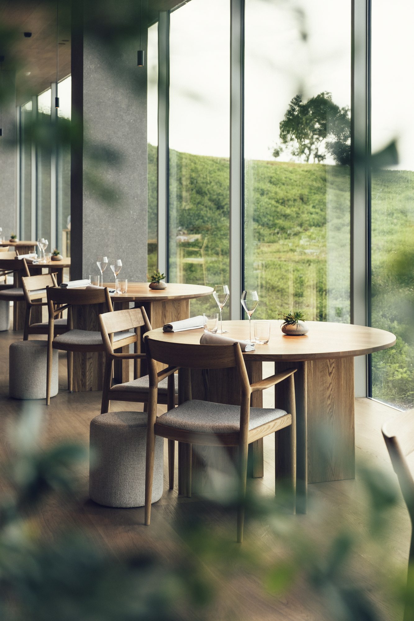 Restaurang ÄNG, Ästad Vingård — gedeckte Tische mit Blick durch raumhohe Fenster in die Landschaft