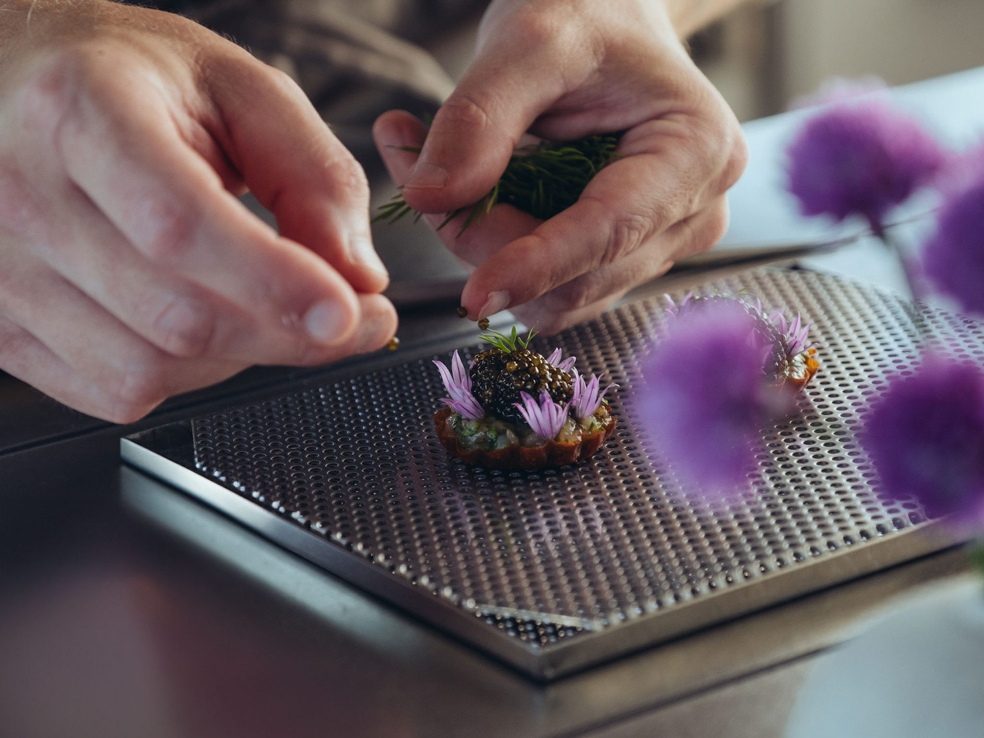 Restaurang ÄNG, Ästad Vingård — Anrichten eines Gerichts mit Blüten