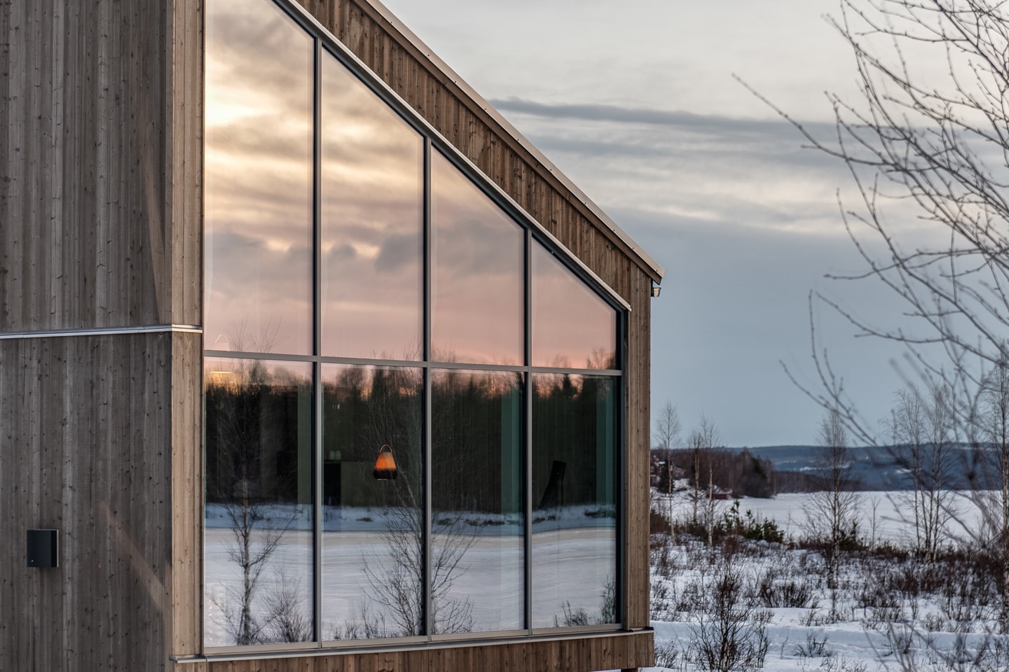 Arctic Bath — Landkabine mit geneigter Glasfront in der Dämmerung