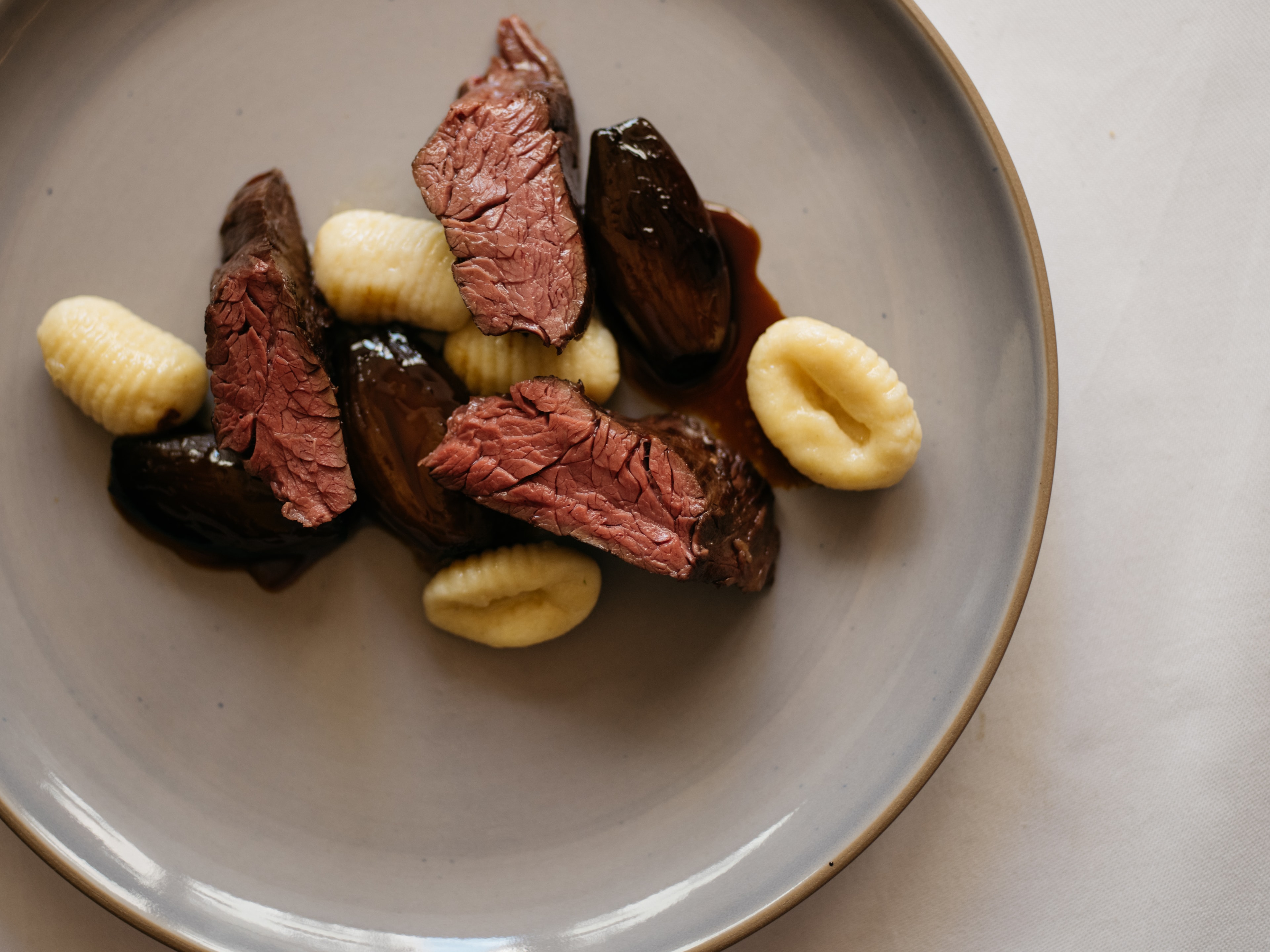Arthotel Blaue Gans — Onglet vom Rind mit Tropea-Zwiebeln und Gnocchi aus der Küche des Restaurants