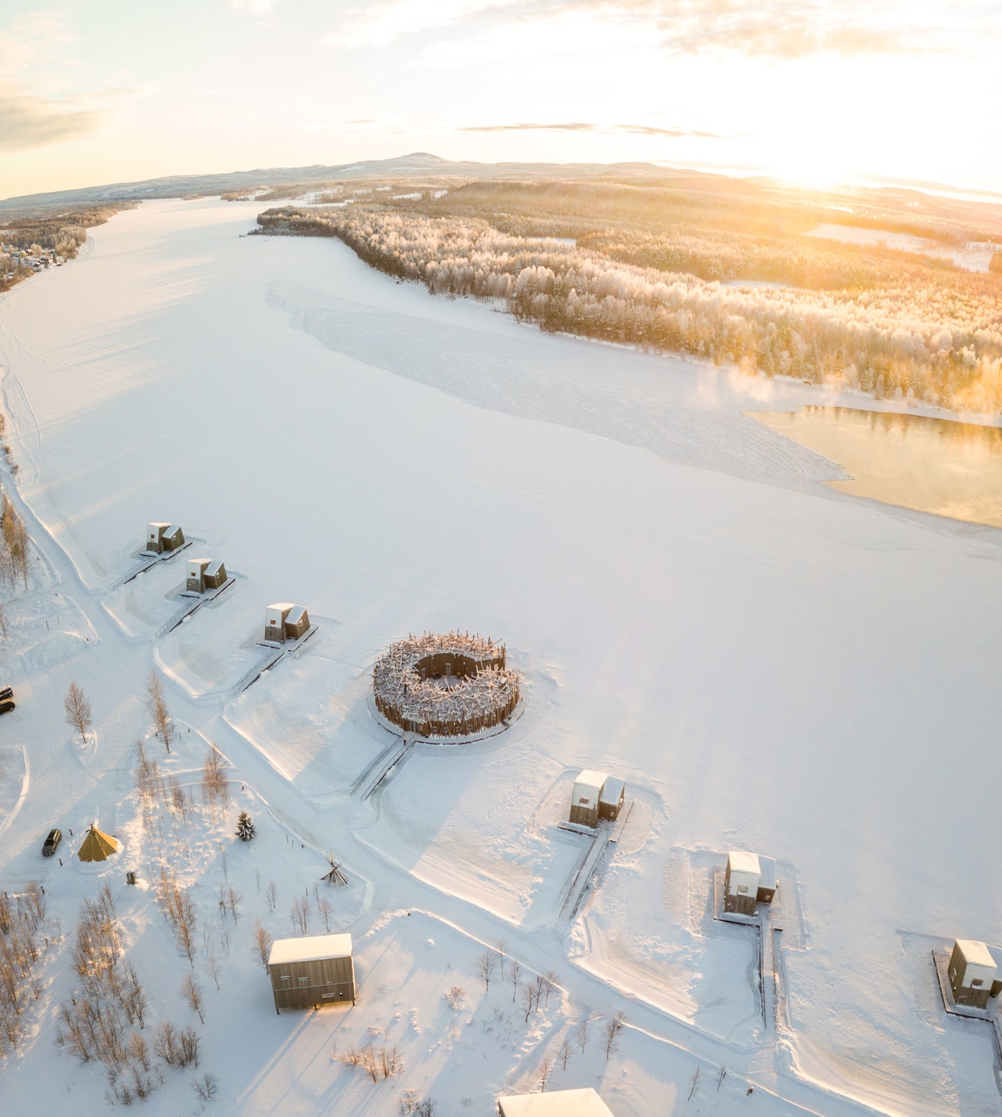 Arctic Bath — Luftaufnahme des schwimmenden Rings im verschneiten Lule-Fluss bei Sonnenuntergang