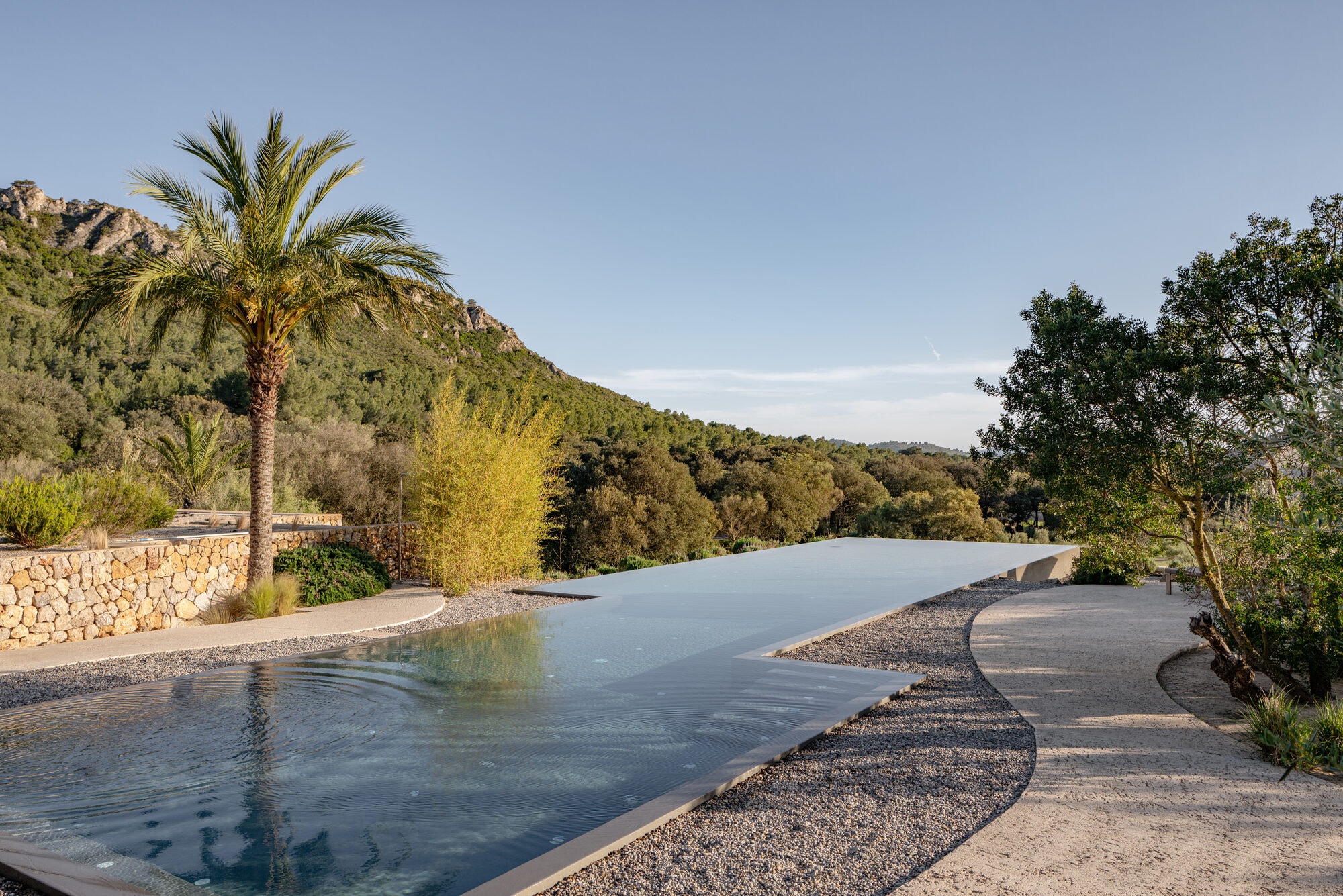 Es Racó d'Artà — Infinity-Salzwasserpool mit Palme und Blick auf die Berge