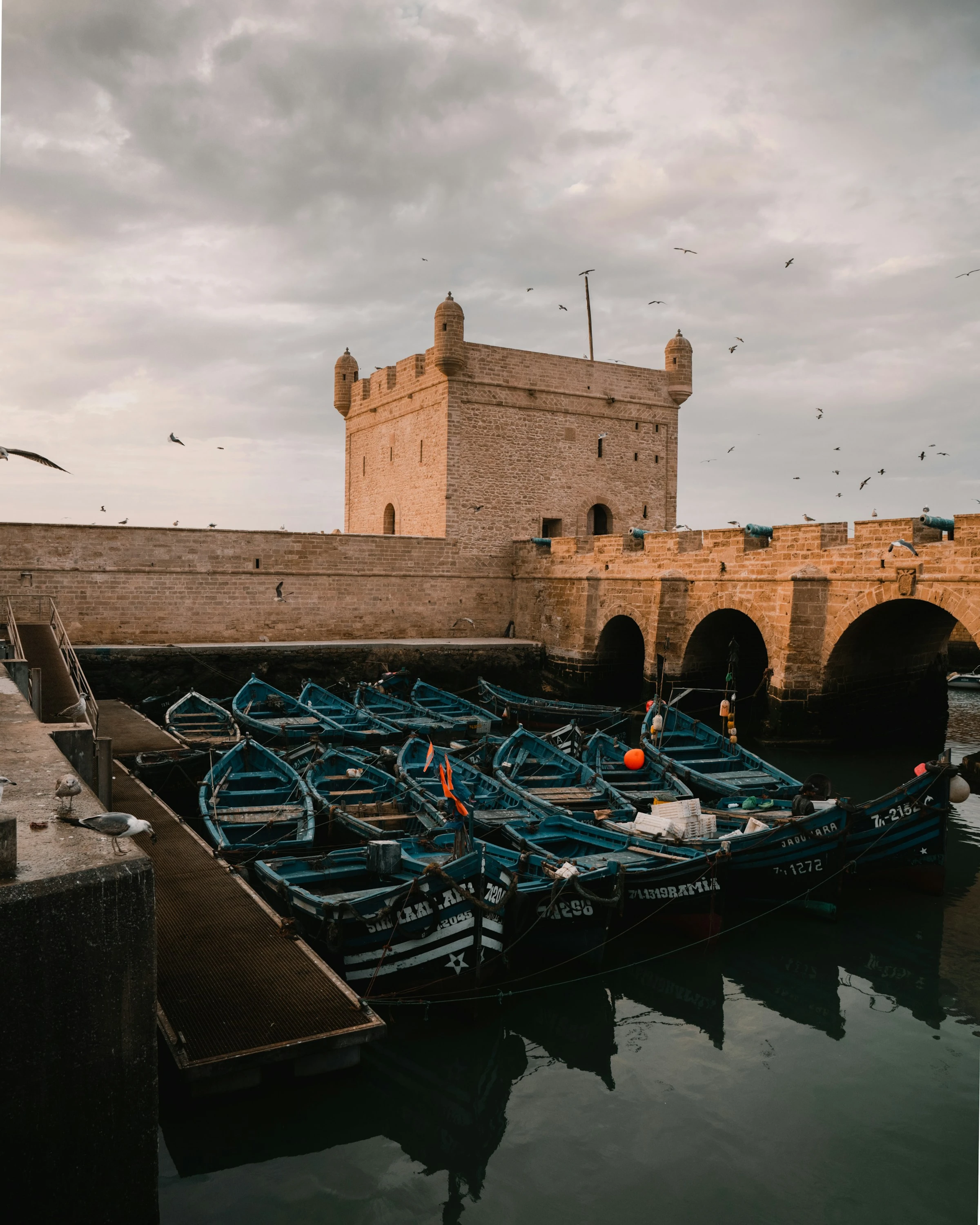 Fishing boats below the Sqala du Port, the bastion guarding Essaouira's harbour. The night's catch is sold at the fish market next door. Photo: Youssef Aboutaleb / Unsplash