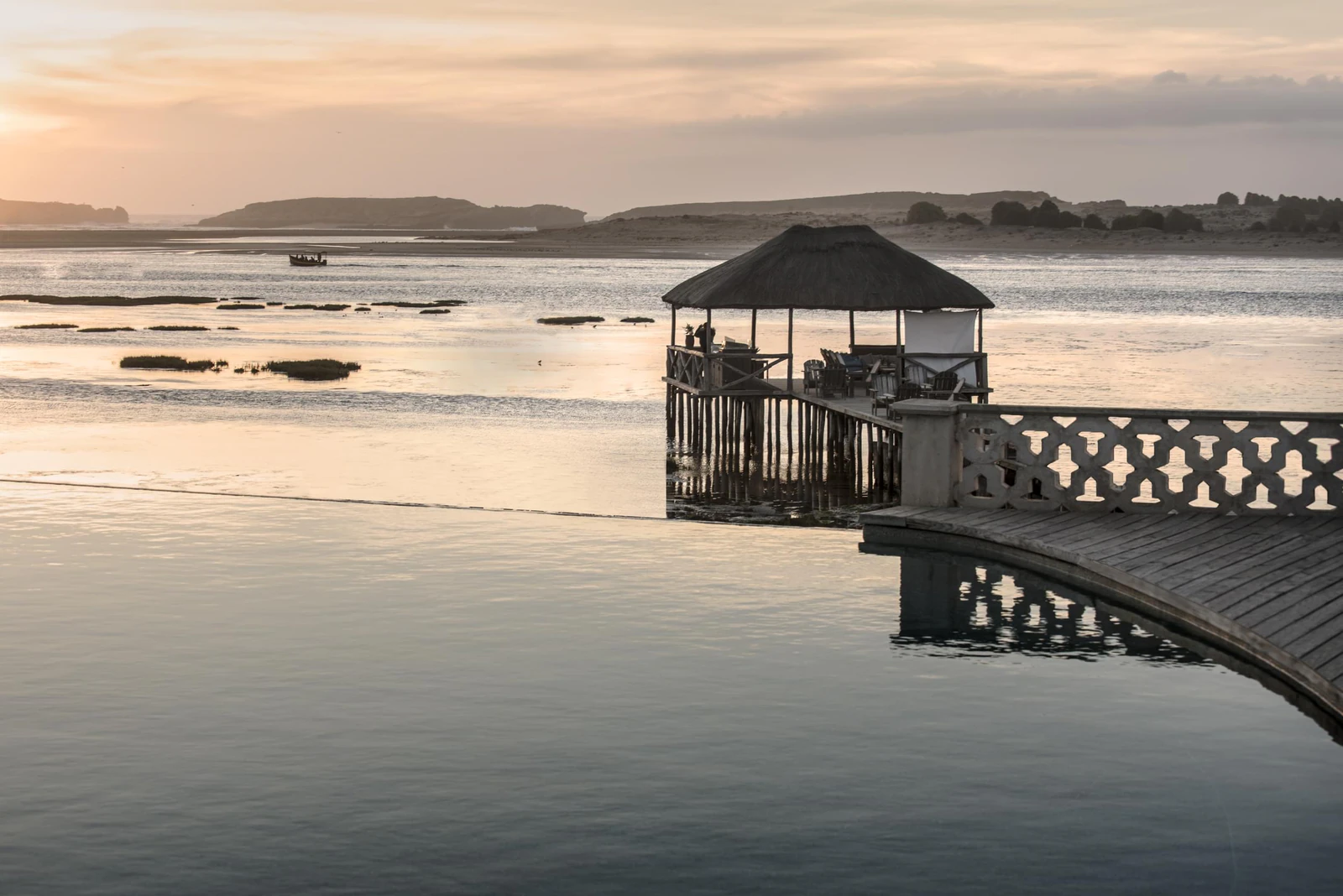 A wooden jetty with a pavilion in the lagoon in the evening light. Photo: La Sultana Oualidia