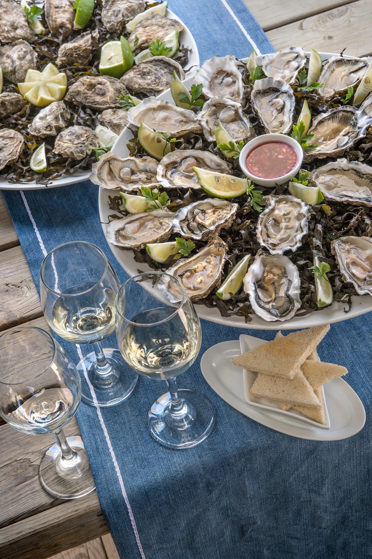 Fresh oysters with lemon, glasses of white wine beside them. Photo: La Sultana Oualidia