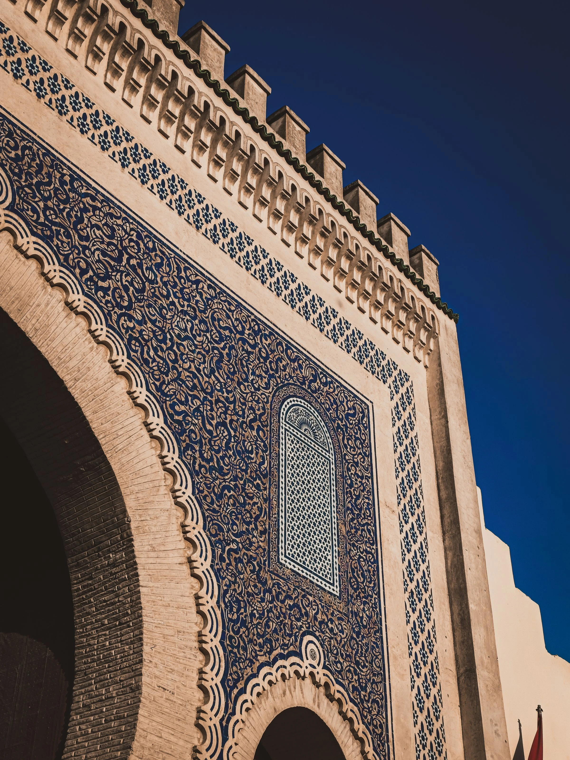 Blau verziertes Mauerwerk und ein Torbogen in Fès. Foto: Med Rofka / Pexels
