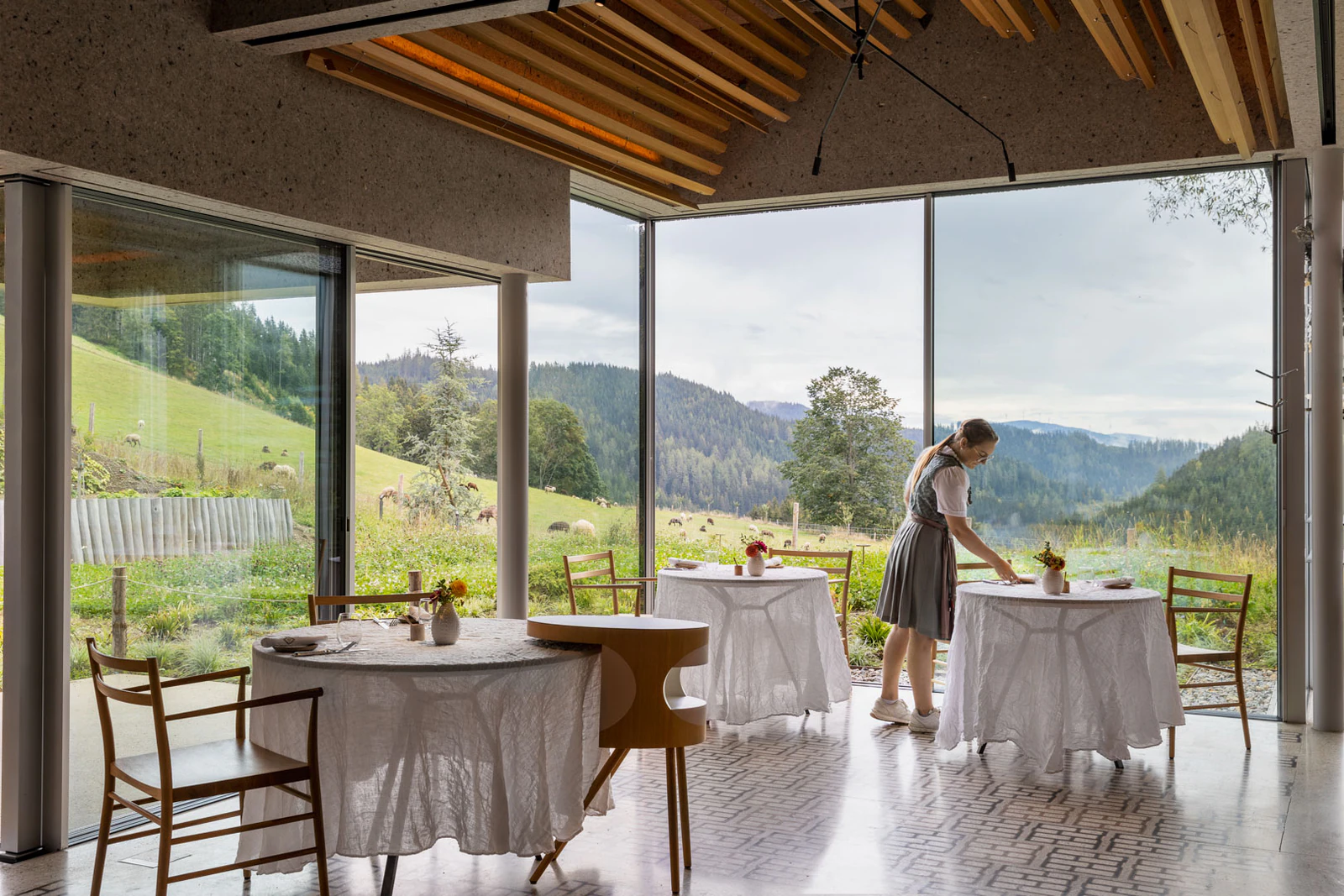 Tables laid with views of meadows and forest. Photo: Steirereck am Pogusch