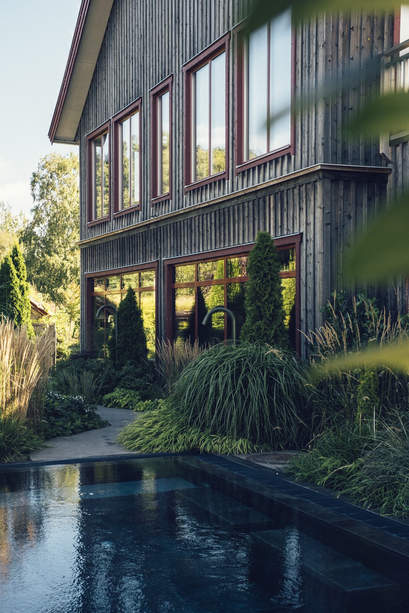 Sinnenas Spa, Ästad Vingård — das holzverkleidete Spa-Gebäude mit Pool und üppigem Garten