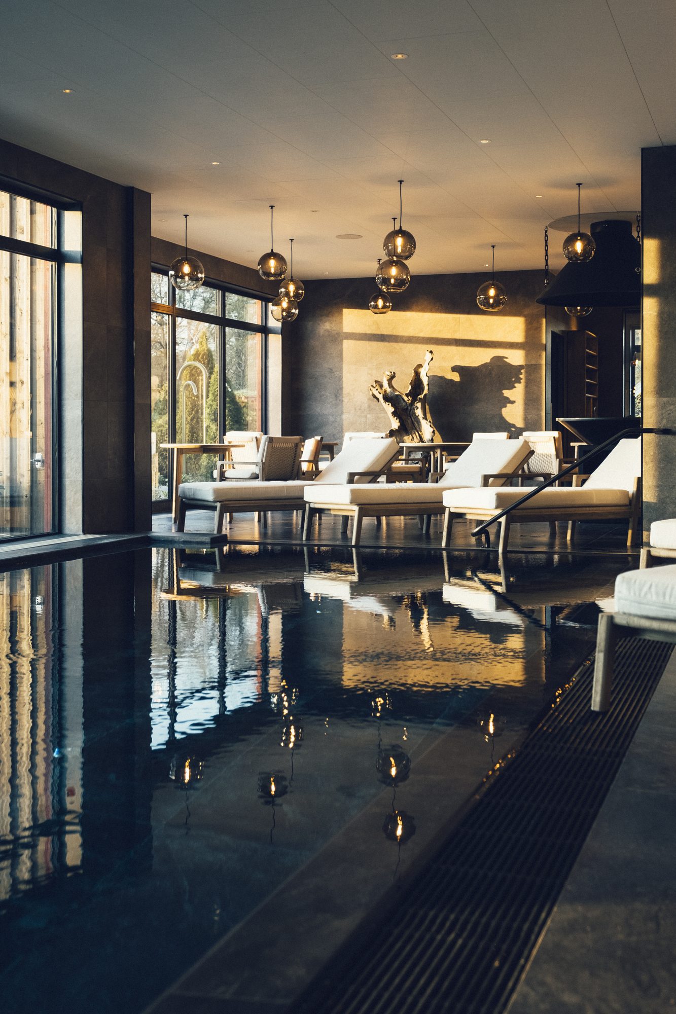 Sinnenas Spa, Ästad Vingård — Innenpool mit Loungebereich, der sich im Wasser spiegelt
