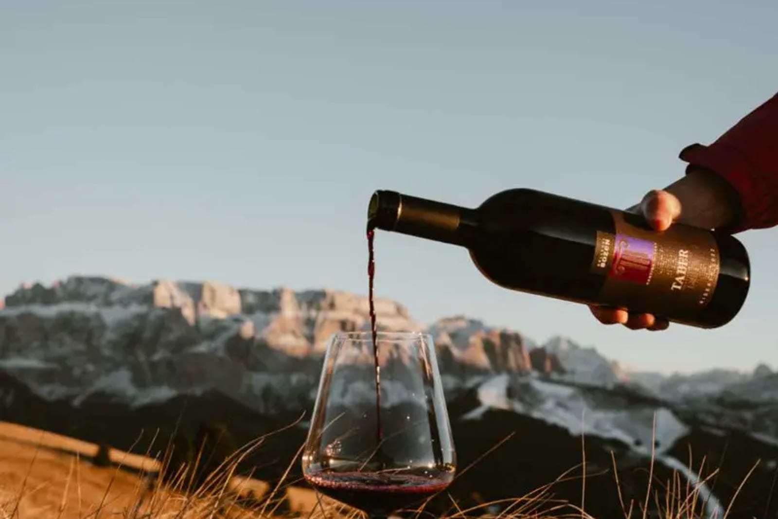 Pouring a glass of South Tyrolean wine for aperitivo, the Dolomites behind