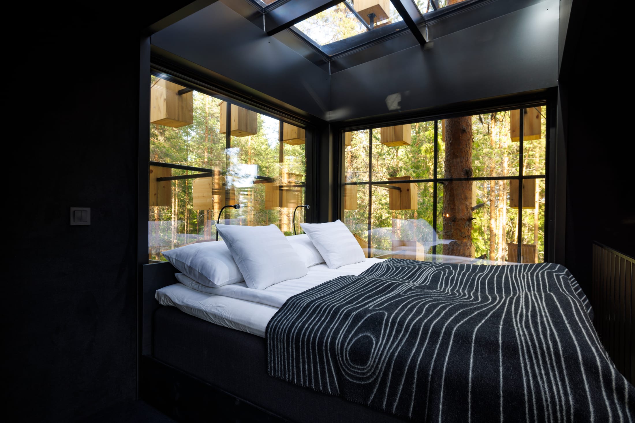 Treehotel — Innenraum der Biosphere mit Glaswänden und Blick auf die umliegenden Vogelhäuser