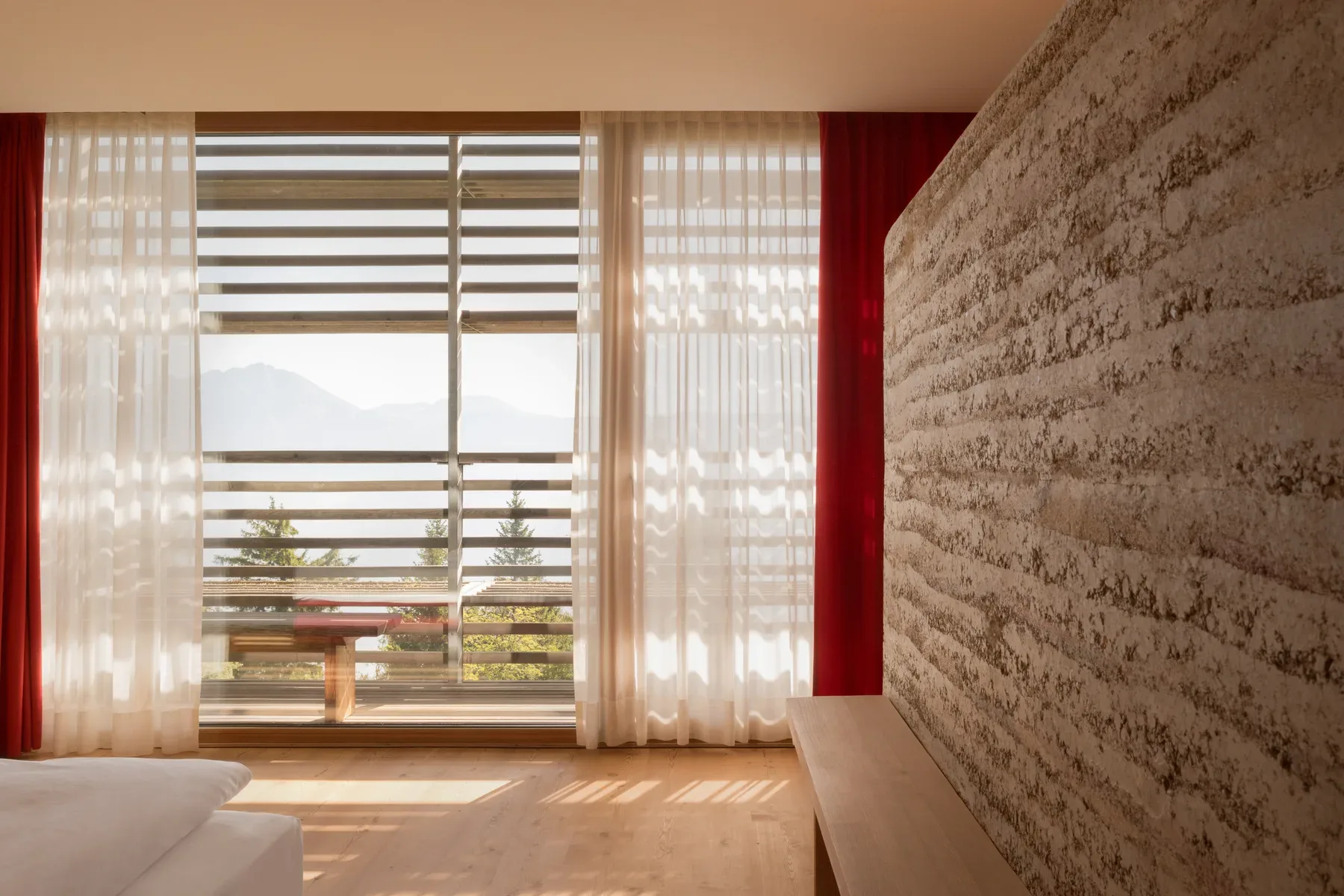 Zimmer aus Lärchenholz, Lehm und Naturstein mit Bergblick im vigilius
